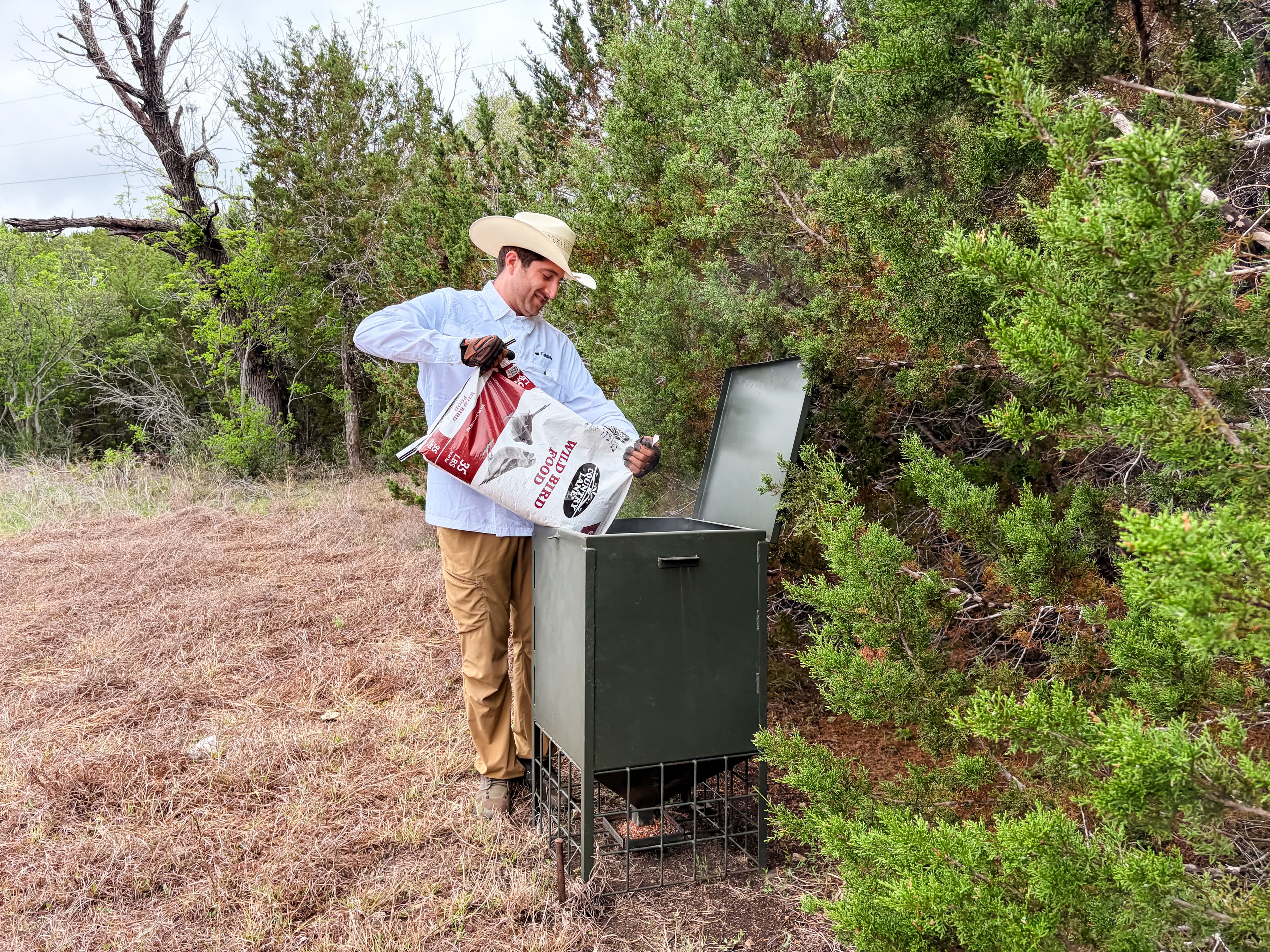 Filling a wildlife feeder on a Texas property